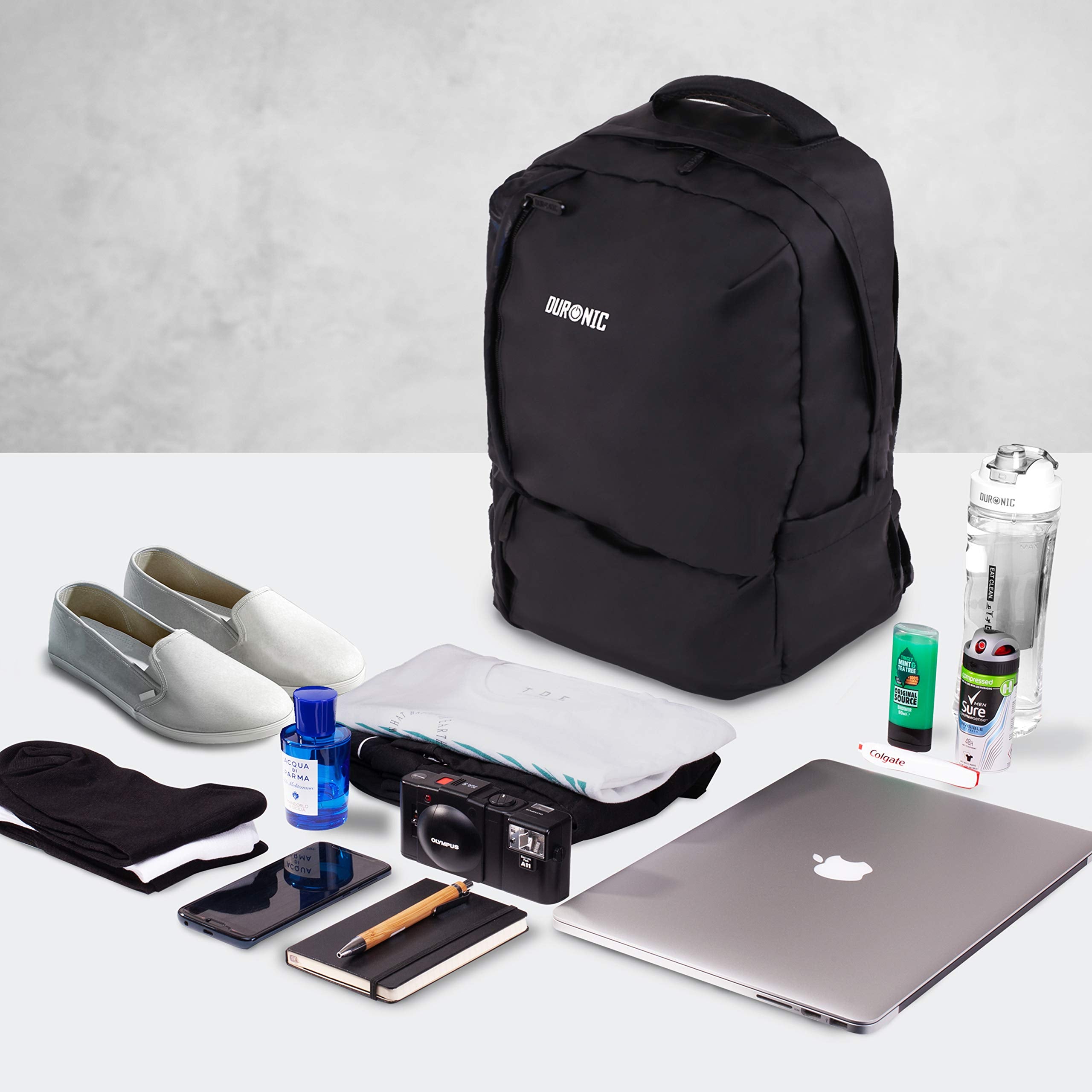 Duronic Laptop Backpack surrounded by neatly laid-out travel items, a laptop, shoes, and toiletries.