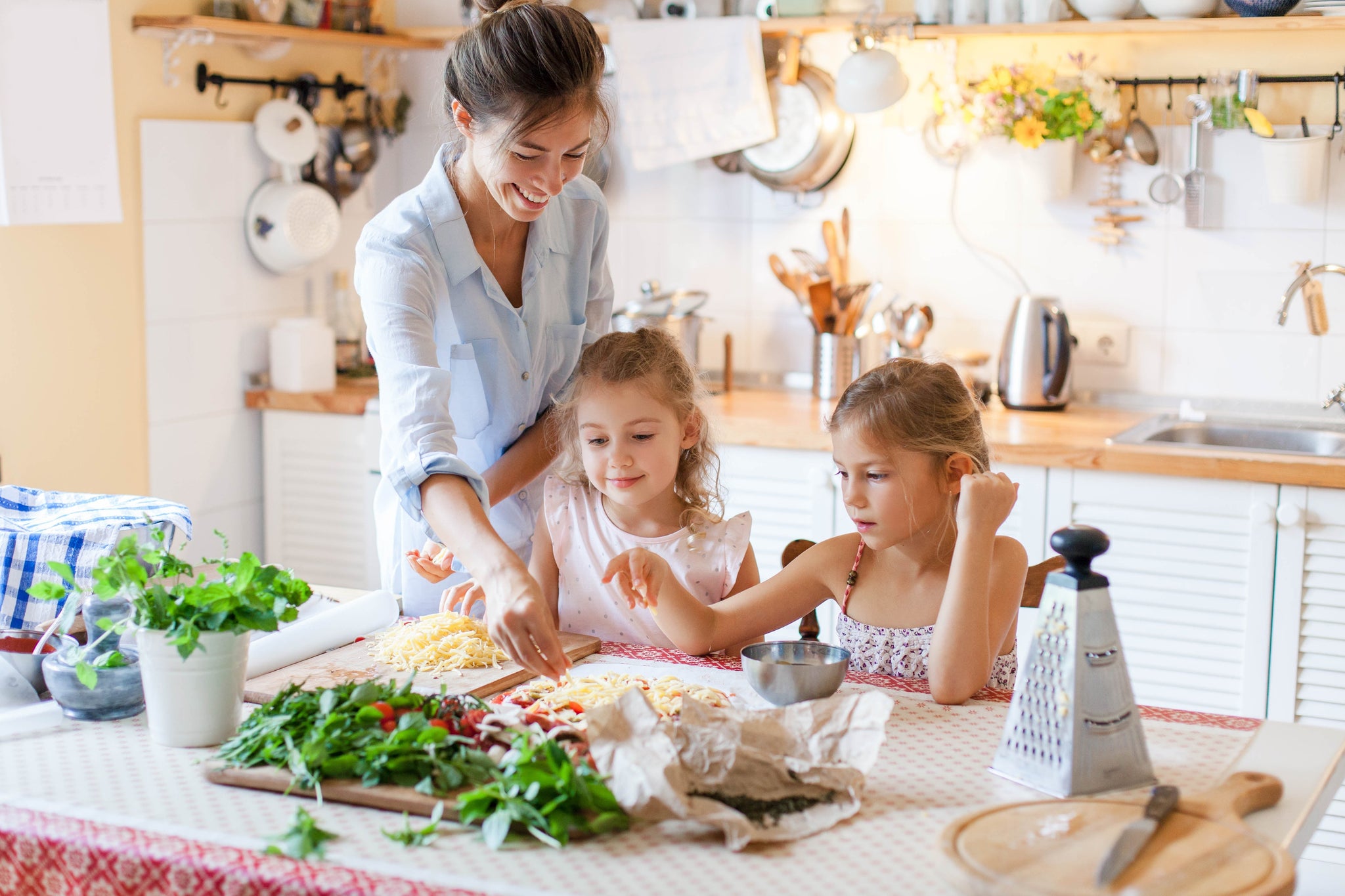 Happy family preparing food with cheese and vegetables to be cooked in the Duronic AF34 dual air fryer