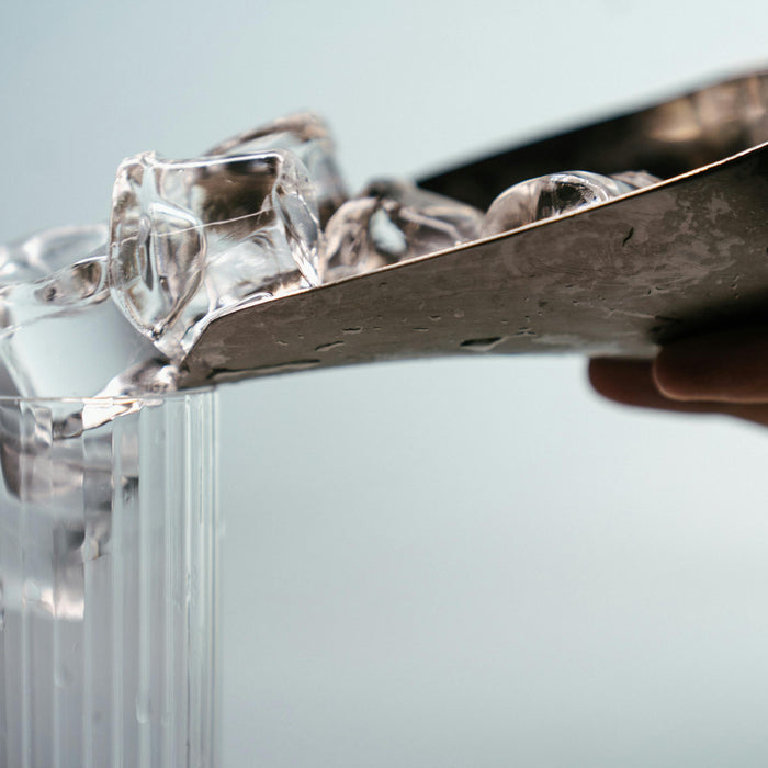 Ice being put into a glass using an ice scooper