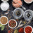 Duronic Electric Salt and Pepper Grinder Set with bowls of colorful spices, sea salts, vintage spoons, and modern spice grinders.