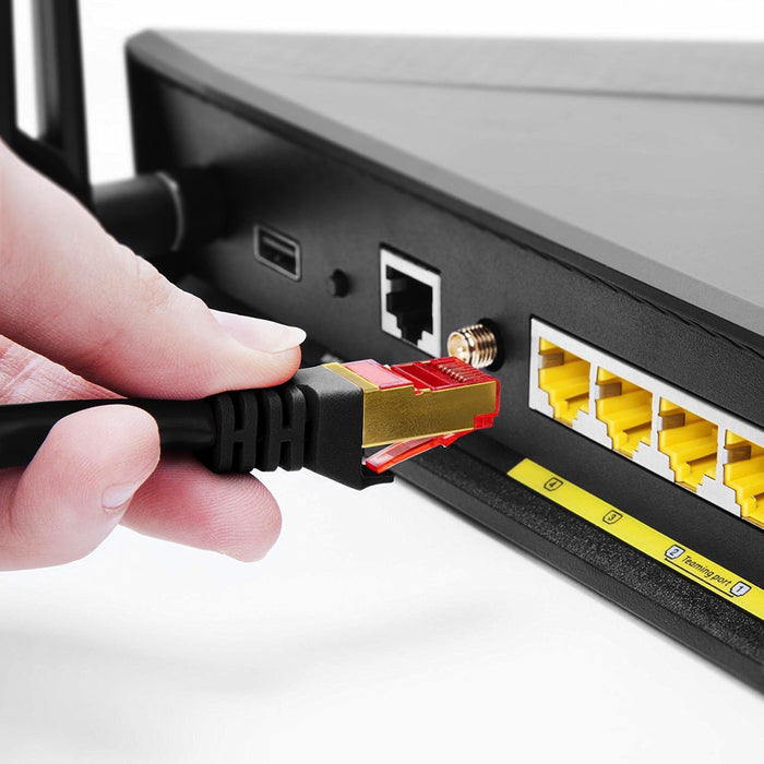 Duronic Ethernet Cable close-up of a hand plugging a high-performance gold-plated Ethernet cable into the rear port of a black gaming router.