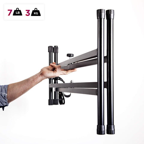 Duronic Keyboard Stand with a person easily lifts a lightweight, folded black metal keyboard stand with one hand.
