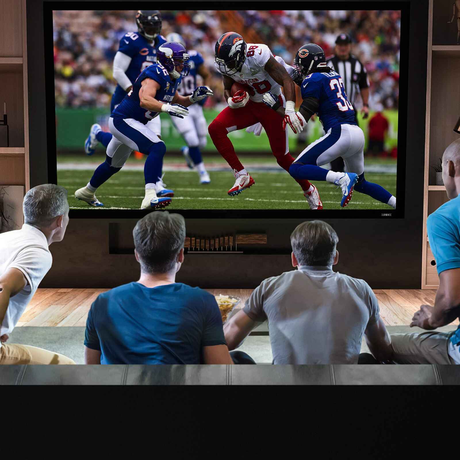 Duronic Projector Screen w Four men watching an American football game on a large, high-definition television screen at home.