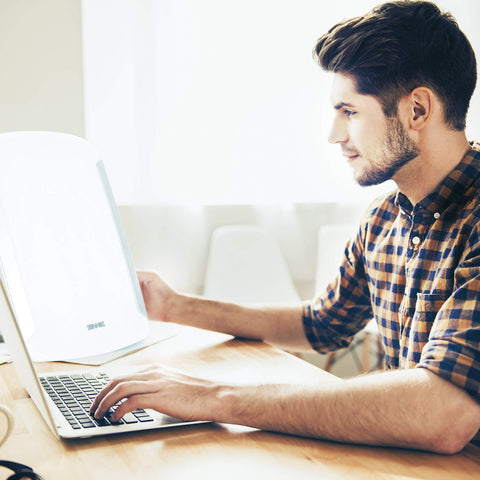 Duronic Sad Light with a man using a laptop at his desk