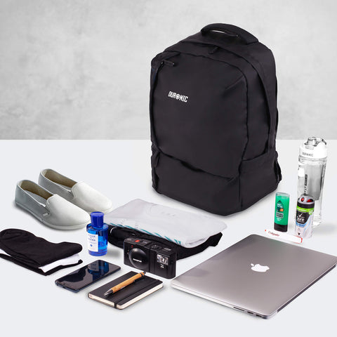 Duronic Laptop Backpack surrounded by neatly laid-out travel items, a laptop, shoes, and toiletries.