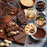 An assortment of decadent chocolate treats, including dark chocolate bars with nuts, cocoa powder, and circular insets featuring chocolate cake, lemon meringue tarts, tiramisu, and donuts.