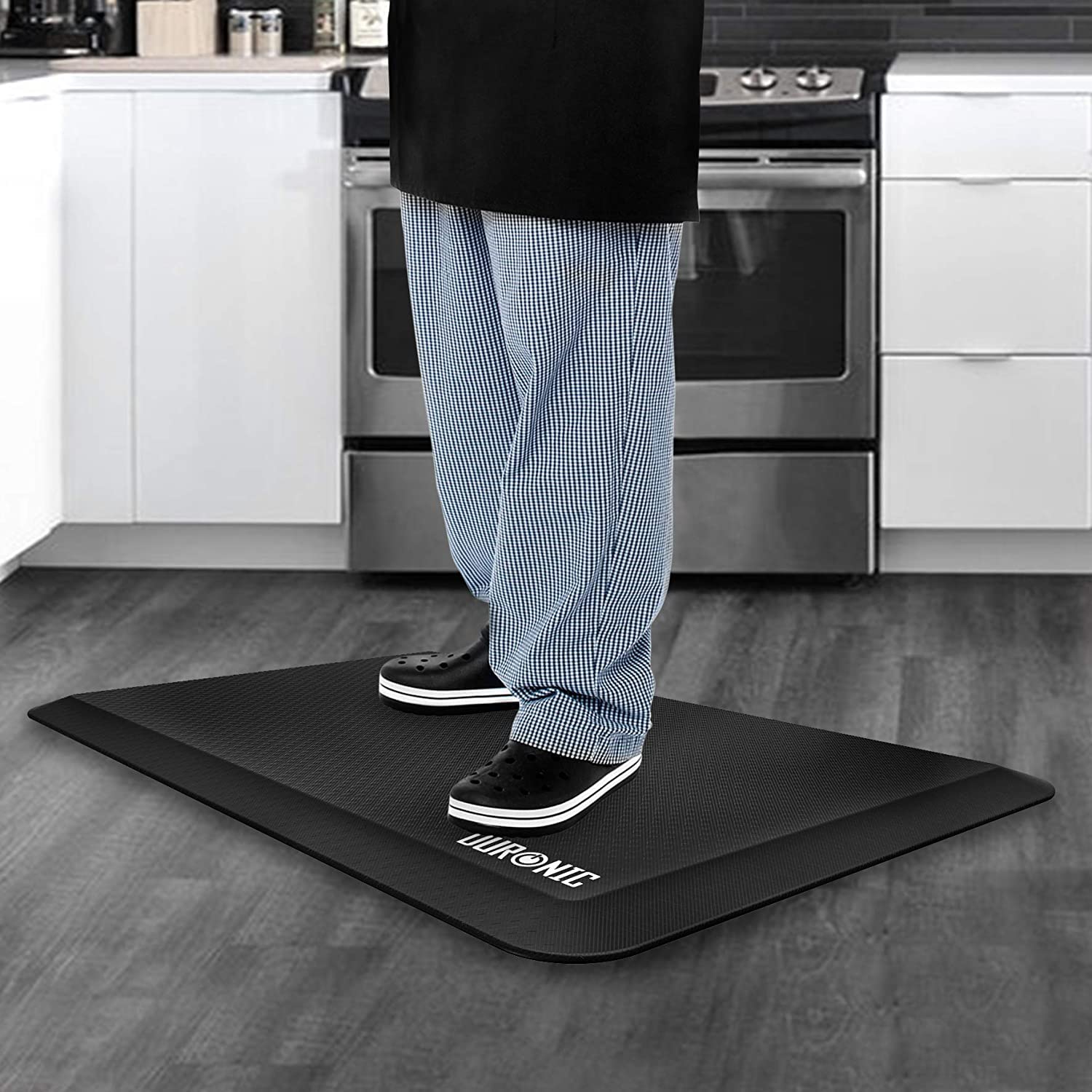 Duronic Anti-Fatigue Mat A person wearing checkered pants and black clogs stands on a mat