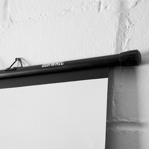 Duronic Bar Projector Screen hanging on a textured white wall.