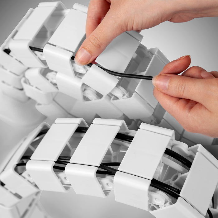 Duronic Cable Management Spine easily tucking a black power cable into a flexible white modular cable management spine for an organized desk setup