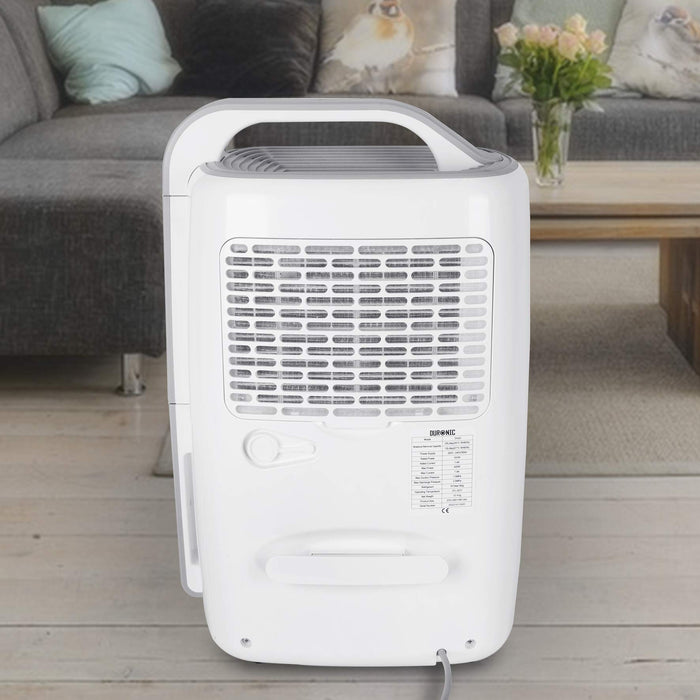 Duronic Dehumidifier featuring a built-in handle, air intake grille, and technical specification label in a living room setting.