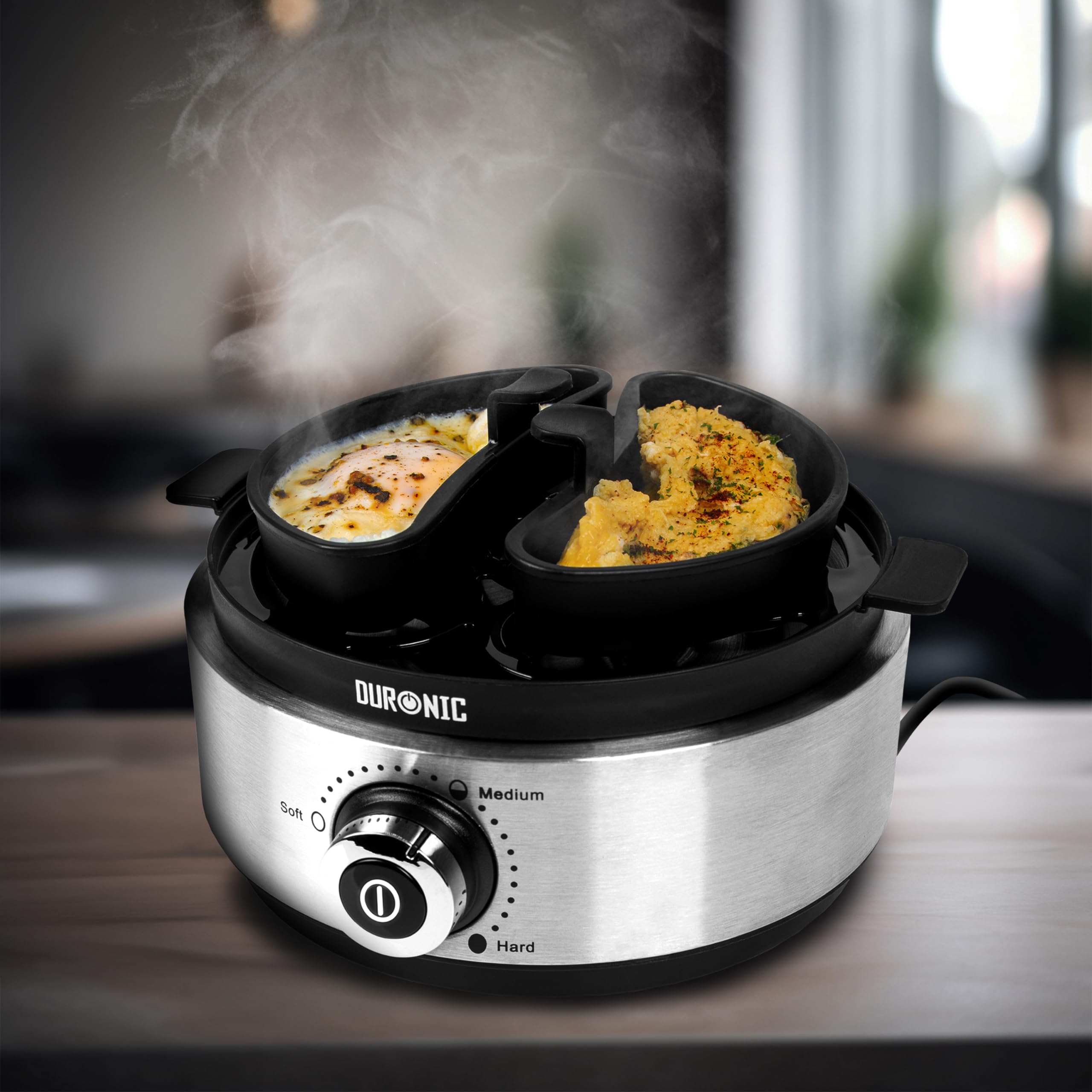 Duronic EB40 BK electric egg boiler cooking eggs in the omelette trays provided, placed aesthetically on a table