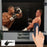 Duronic Electric Projector Screen displaying a boxing match while a hand operates it with a remote.