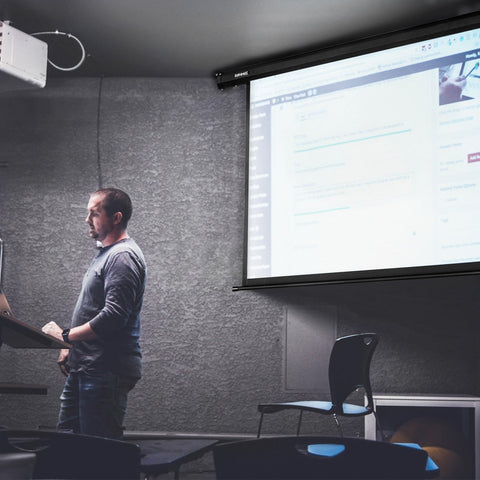 Duronic Electric Projector Screen with a man presenting in podium