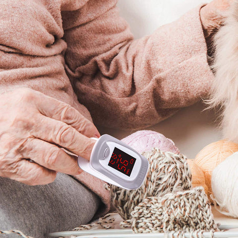 Duronic Fingertip Pulse Oximeter with balls of yarn nearby.