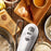 Duronic Hand Mixer Electric Whisk on a wooden table surrounded by baking ingredients, flour, and eggshells.