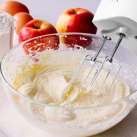 Duronic Hand Mixer Electric Whisk with apples and eggs in the background.