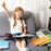 Duronic Laptop Tray with smiling young girl using a portable lap desk on a couch with school supplies nearby