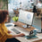 Duronic Monitor Stand Riser on a white desk with a woman working in an office.