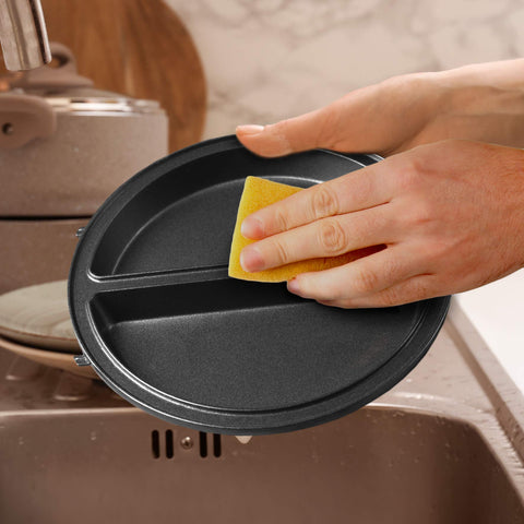 Duronic OM60 electric omelette maker dual non-stick cooking plates being washed with sponge