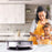 Duronic PM131 electric crepe maker placed on an aesthetic kitchen countertop with a family preparing ingredients