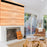 Duronic Projector Screen featuring a white brick fireplace, wood wall paneling, and unique wooden furniture."