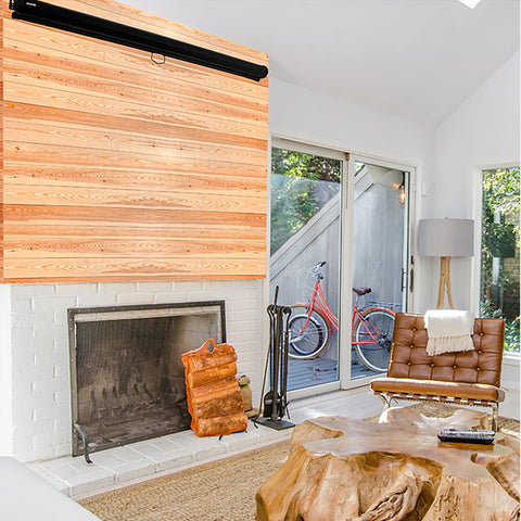 Duronic Projector Screen mounted on a wood accent wall above a white brick fireplace.
