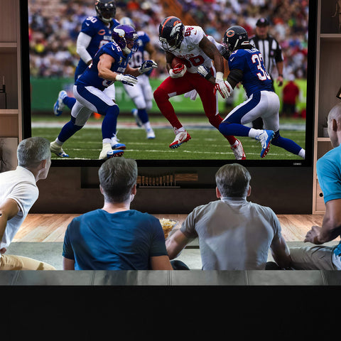 Duronic Projector Screen shown Four men sitting on a couch watching an American football game on a large TV screen.