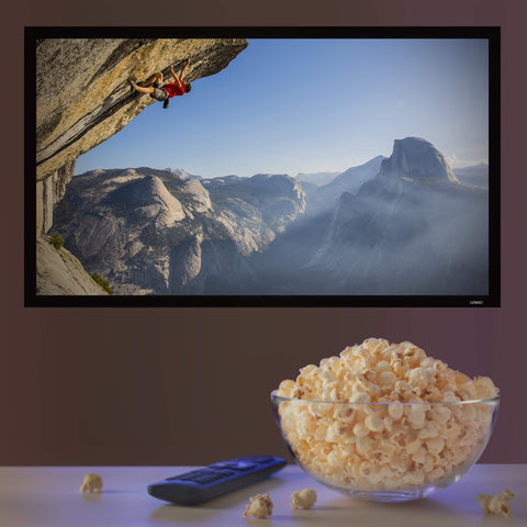 Duronic Projector Screen with A TV playing a rock climbing documentary on a wall above popcorn and a remote.