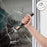 Duronic Rechargeable Torch Flashlight breaking through a glass window pane, demonstrating impact strength and emergency durability features.
