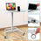 Duronic Sit-Stand Desk featuring a laptop, device slot, gas lift lever, and wheels.