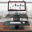 Duronic Sit-Stand Desk featuring a two-tier design with an iMac on the top shelf and a wireless keyboard and mouse on the lower tray.