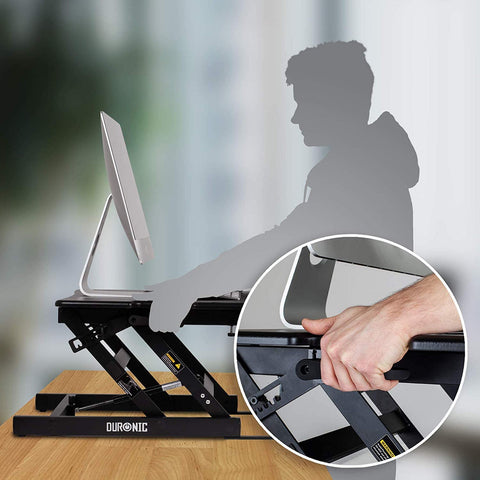 Duronic Sit-Stand Desk showing a hand pulling the height adjustment lever.