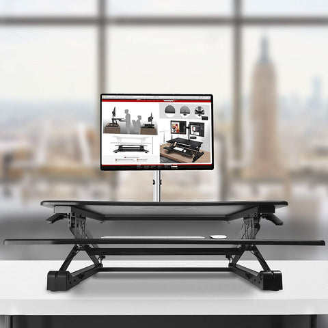 Duronic Sit-Stand Desk with a monitor mount, holding a screen on a table.