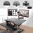 Duronic Sit-Stand Desk with dual monitor mount installed via a grommet hole.