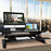 Duronic Sit-Stand Desk with dual monitors, keyboard, and mouse on a wooden table.