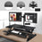 Duronic Sit-Stand Desk with keyboard tray, featuring dual monitors mounted via grommet hole..