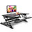 Duronic Sit-Stand Desk with two tiers holding a computer, keyboard, and tablet.