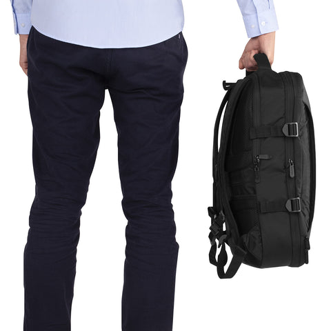 Duronic Travel Cabin Bags with Man holding a black commuter backpack by its top handle next to his leg.