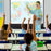 Duronic Tripod Projector Screen with a smiling teacher pointing at a world map
