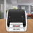 Duronic desktop thermal label printer printing a white barcode label on a wooden office desk.