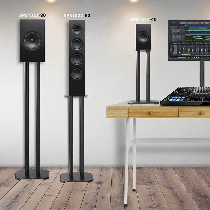 Three different sizes of black speaker stands supporting audio monitors in a music studio setting.